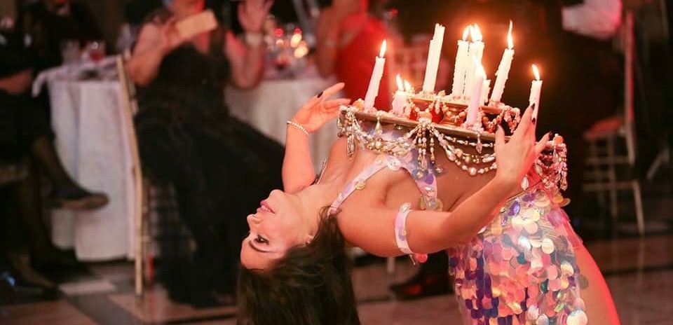 Bellydancer at a wedding balancing a candle tray in her live performance